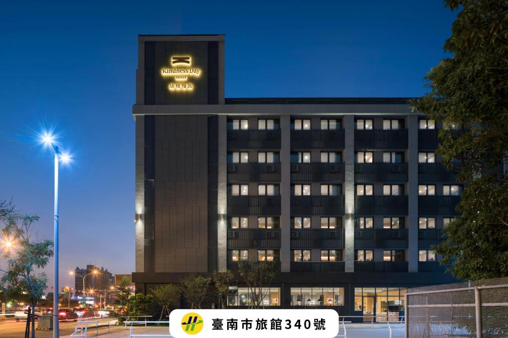 a building with a sign on top of it at Kindness Day Hotel in Tainan