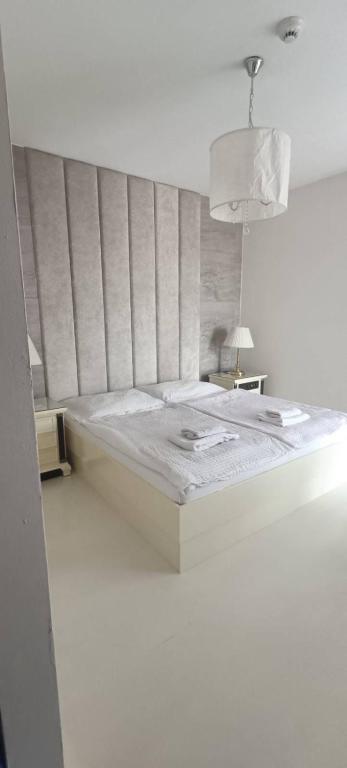 a bed in a white room with a bedvisor at Hotel Velky Meder in Veľký Meder