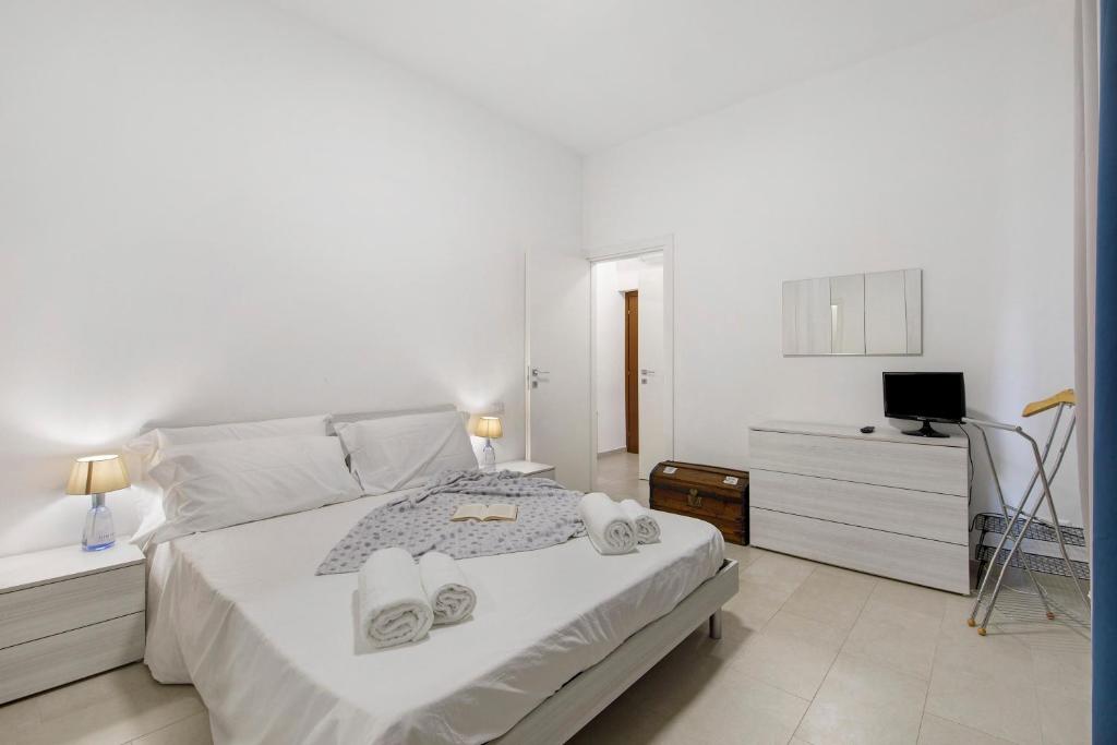 a white bedroom with a bed and a television at Appartamento Zia Nena in Zelo Buon Persico
