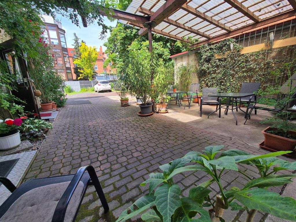 a patio with a table and chairs and plants at Apartments Schramm in Eisenach