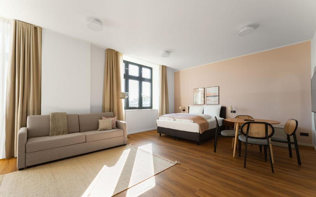 a hotel room with a bed and a couch and a table at Limehome Gelsenkirchen Hochstr in Gelsenkirchen