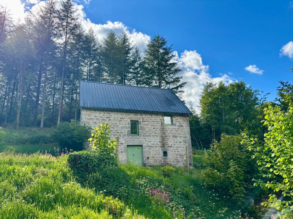 an old stone barn in the middle of a field at Le Gîte de Couturas in Saint-Hilaire-les-Courbes