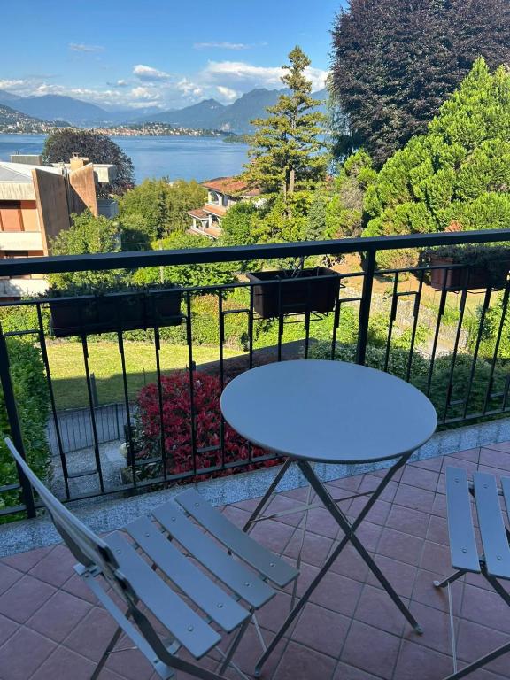 a table and chairs on a balcony with a view of the water at Nice Gecko in Baveno