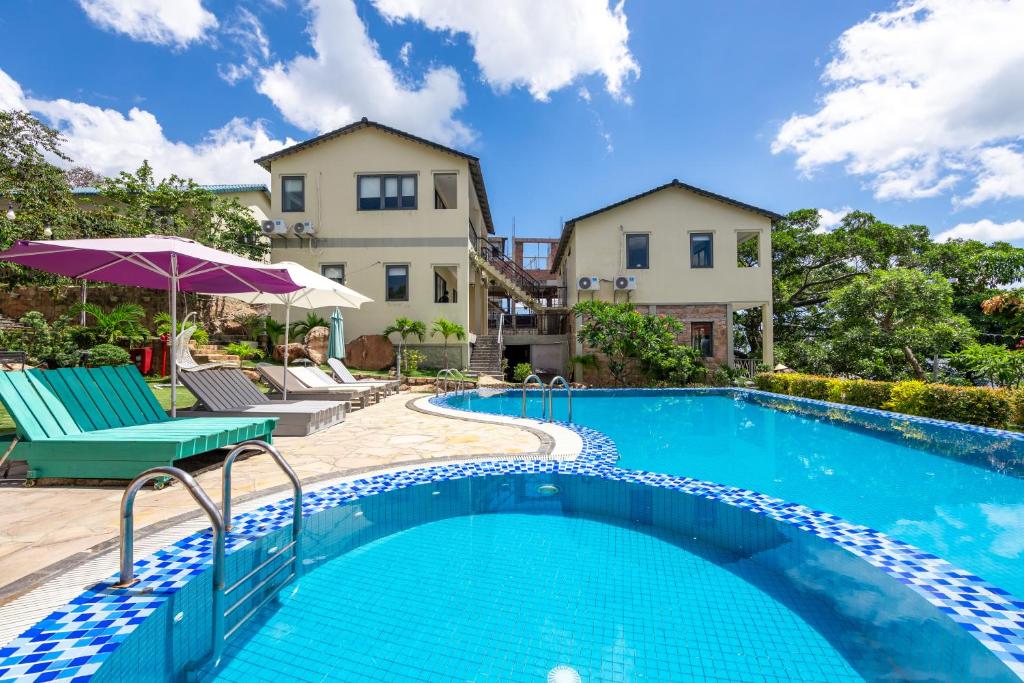 a swimming pool with chairs and a house at Casa De Sol Resort - Wuwei Retreat in Phú Quốc