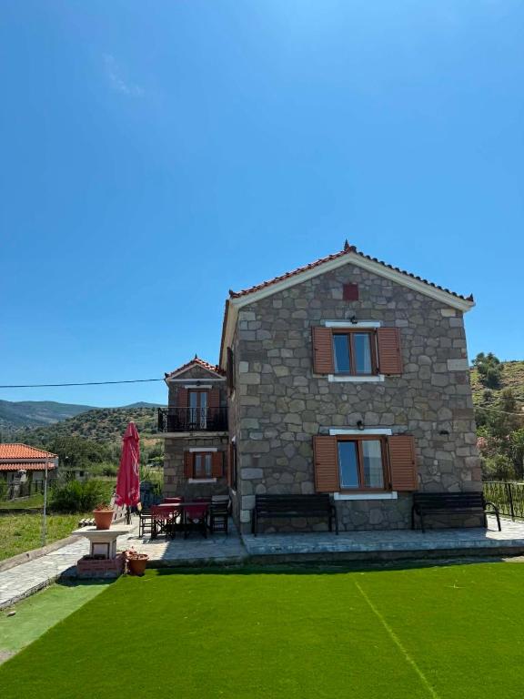 a stone house with a lawn in front of it at Aura Seaside Apartments in Petra