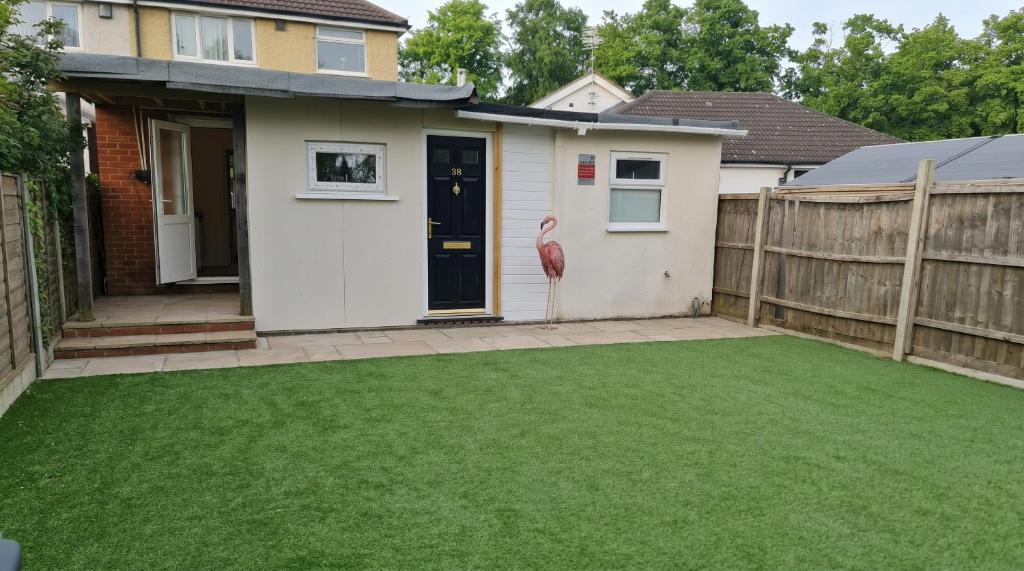 a backyard with a fake lawn in front of a house at 1 Bedroom studio in Datchet