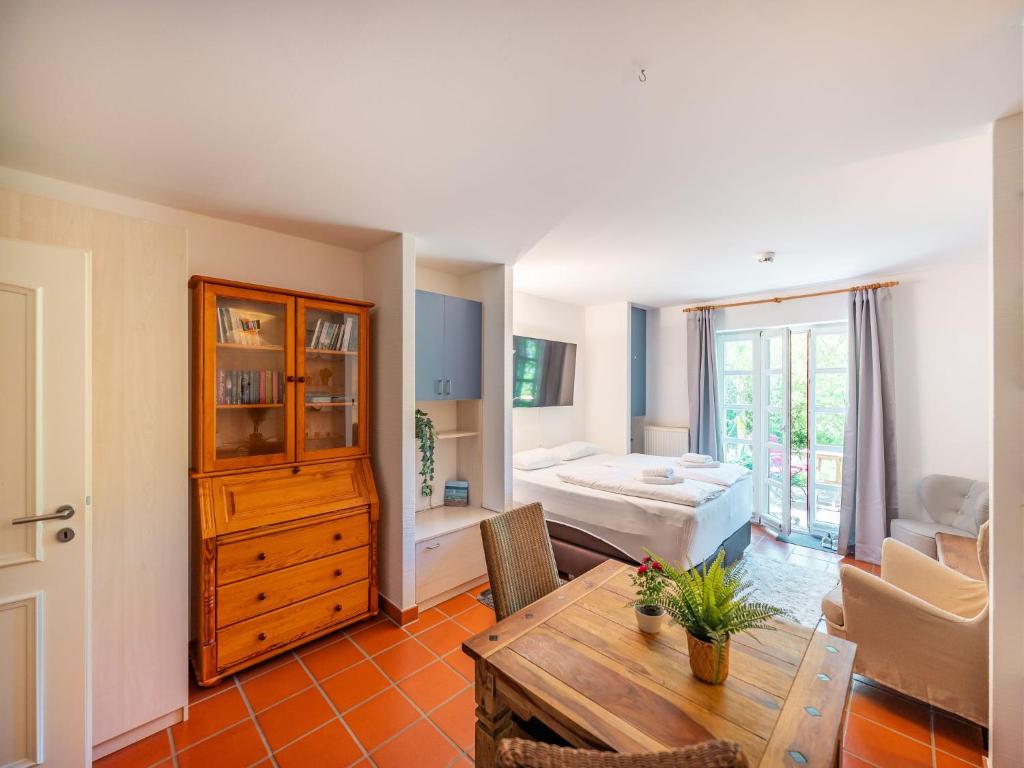 a living room with a table and a bedroom at Feriendorf Rugana - Klassik 1-Raum Ferienwohnung mit Terrasse B59 in Dranske