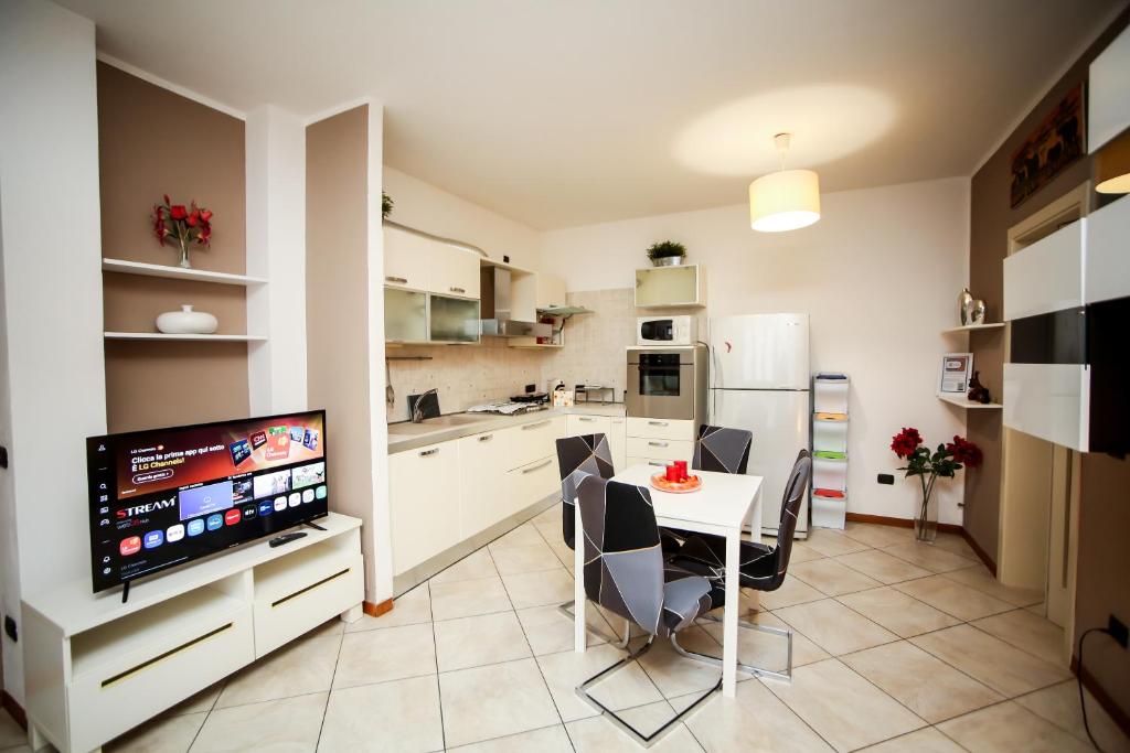 a kitchen and dining room with a table and a television at Guest House Sassuolo 2 in Sassuolo