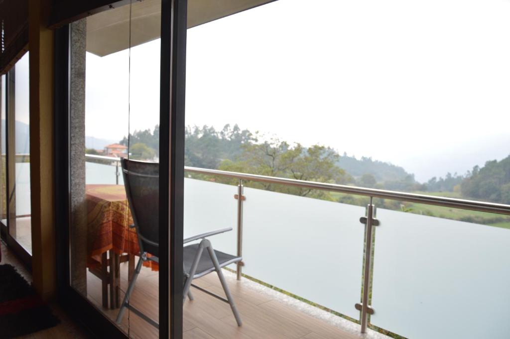 a room with a balcony with a view of the water at Casa Vale Quintao in Geres