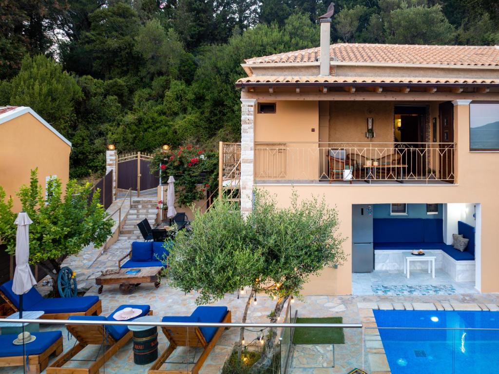 a villa with a swimming pool and a house at Olive & Wave Cottage in Karousádes
