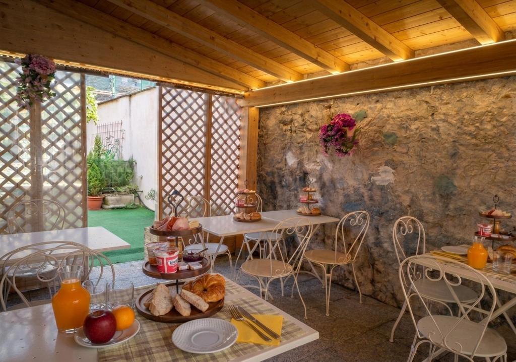 a room with two tables and chairs with food on them at B&B near Lake Como - Close to train & bus - Breakfast included in Valmadrera