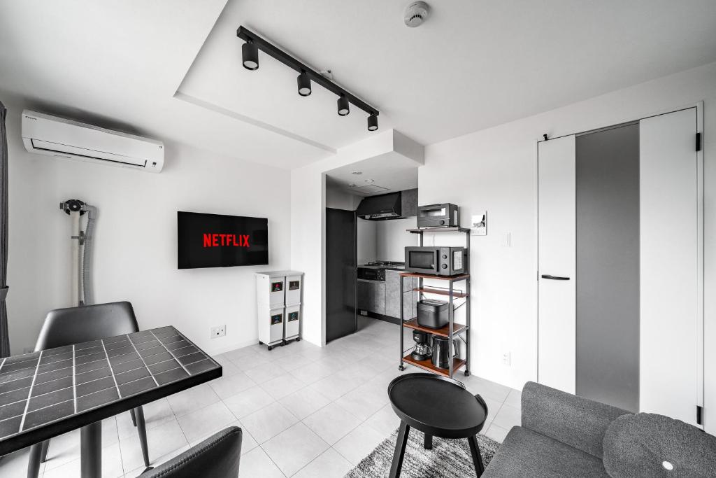 a living room with a table and chairs and a kitchen at Astage Chitose Suehiro 103 in Chitose