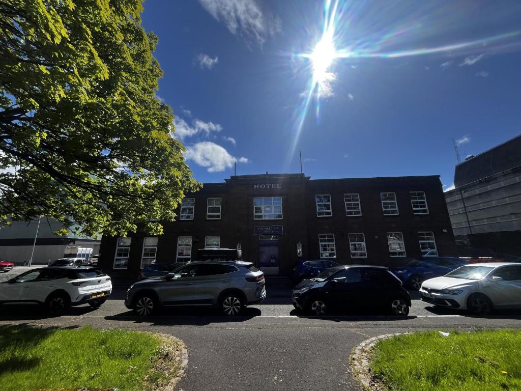 a parking lot with cars parked in front of a building at The Harbour Hotel in Greenock