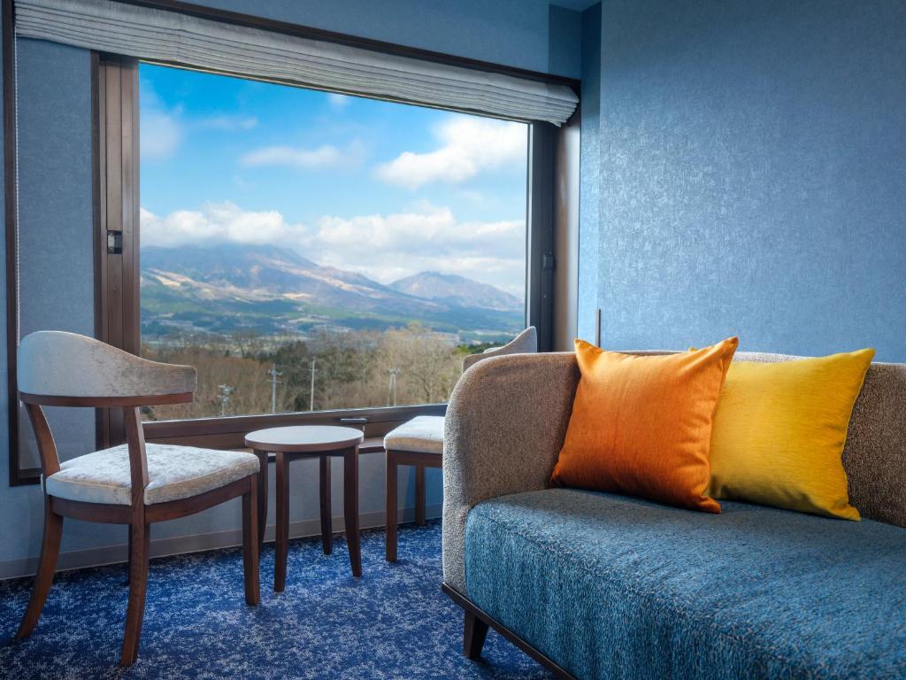 a room with a couch and a large window at La Vista Minami Aso Grand opening October 2nd 2026 in Minami Aso
