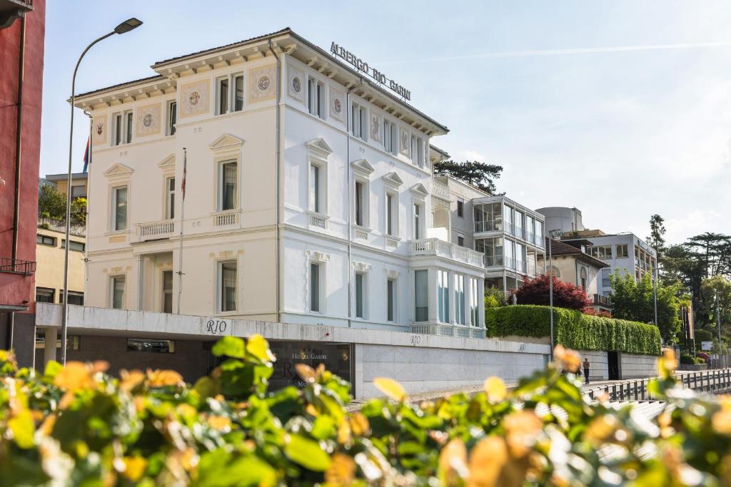 ein weißes Gebäude in einer Stadtstraße in der Unterkunft Hotel Rio Muralto in Locarno