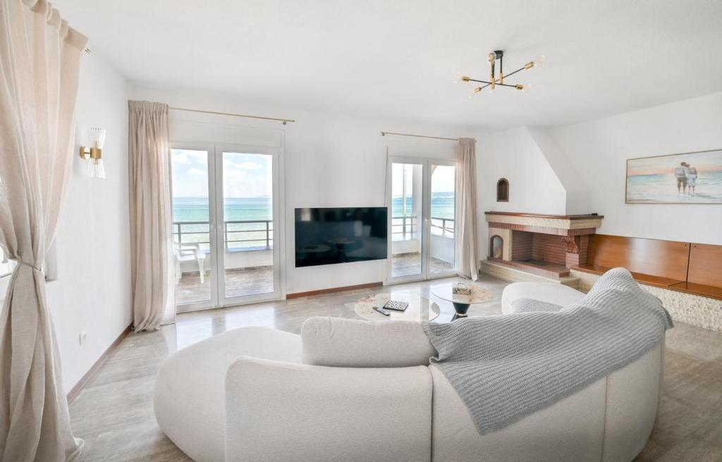 a living room with a white couch and a tv at Cleopatra Residence in Perea