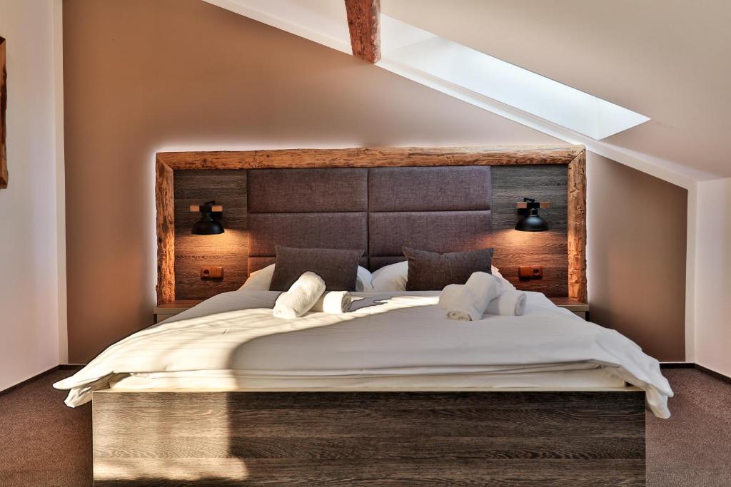 a bedroom with a large bed with a wooden headboard at Třebovický mlýn in Ostrava