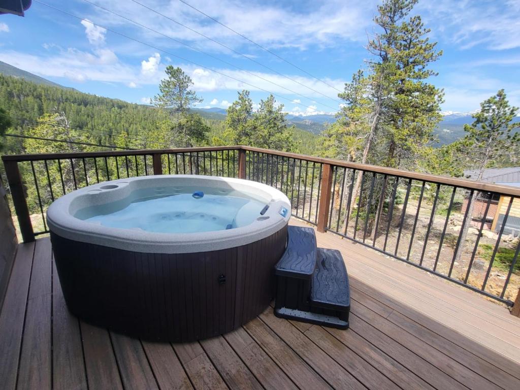 a jacuzzi tub on a deck with a view at Stone Cliff Cottage in Golden