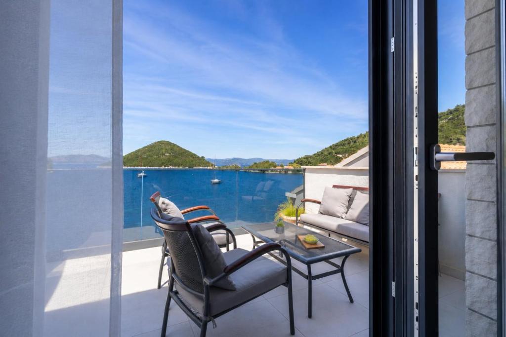 a patio with a view of the water through glass doors at Azure Adriatic in Prožura