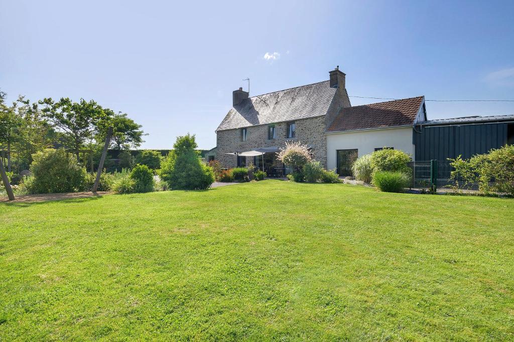 a house with a large lawn in front of it at Gite Du Bois in Ponts