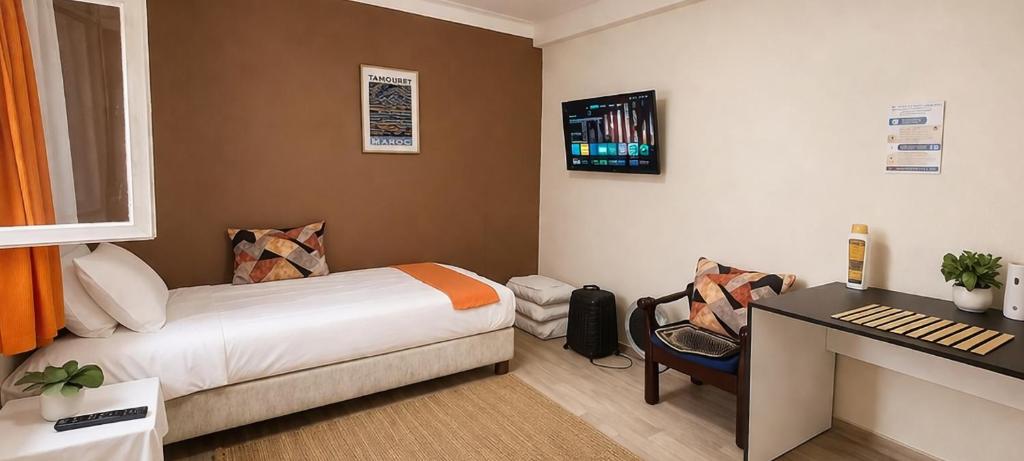 a bedroom with a bed and a desk with a keyboard at Majestic Room in Agadir