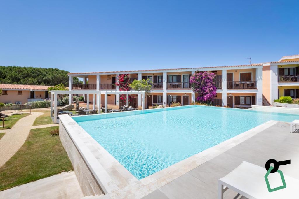 a swimming pool in front of a building at Hotiday Punta Sardegna in Palau