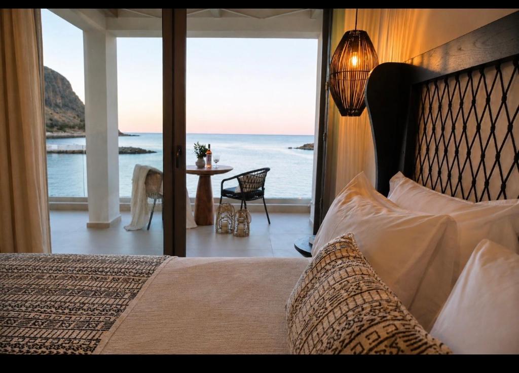 a bedroom with a bed and a view of the ocean at Aether-Castle vista in Monemvasia