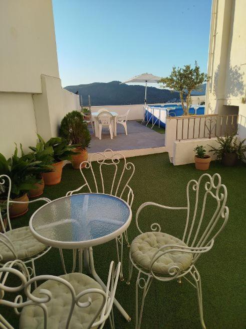 a patio with a table and chairs on a balcony at La Venta Casa Rural in Benitachell