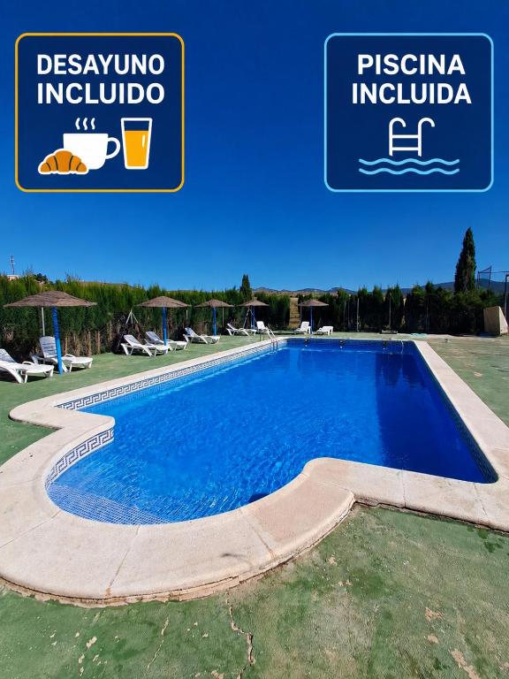 a swimming pool in a resort with a sign that reads piscina indula at Cortijo Ojos del Prado in Caravaca de la Cruz