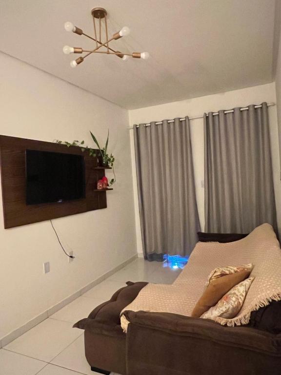 a living room with a couch and a flat screen tv at Aconchego e conforto in Bom Jesus da Lapa