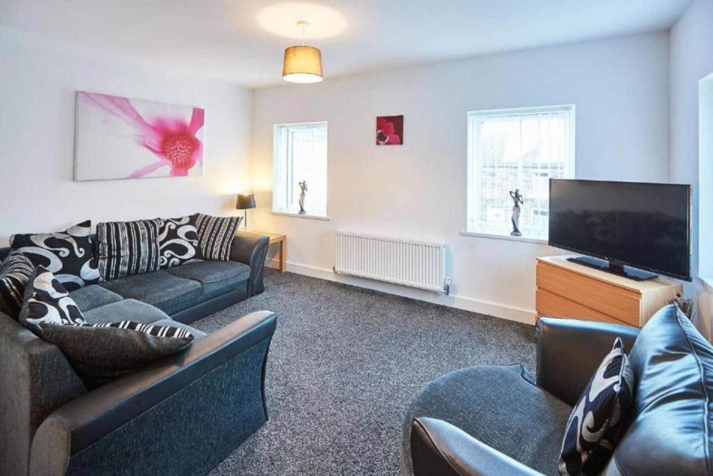 a living room with couches and a flat screen tv at Skinningrove Beach House 1 in Skinningrove