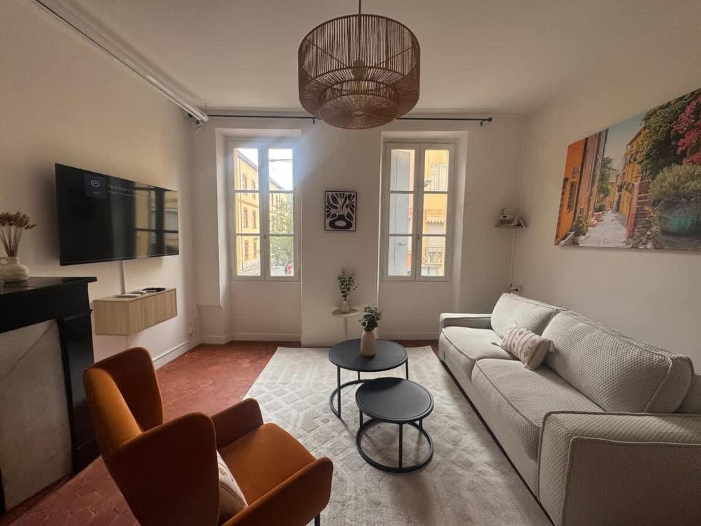 a living room with a couch and a tv at Le Régent - Perpignan city center in Perpignan