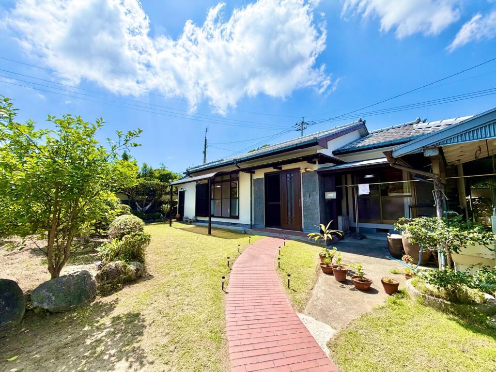 a house with a brick walkway in front of it at 別邸 先山 in Kamikatetsu