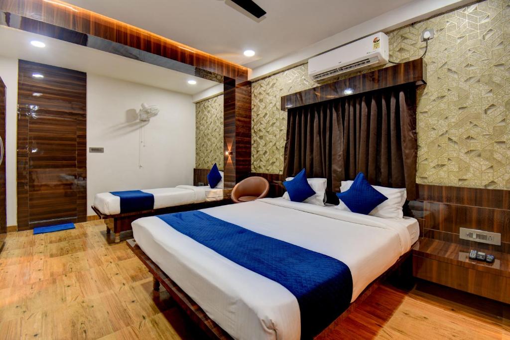 a hotel room with two beds and a television at Hotel Joy in Chākan