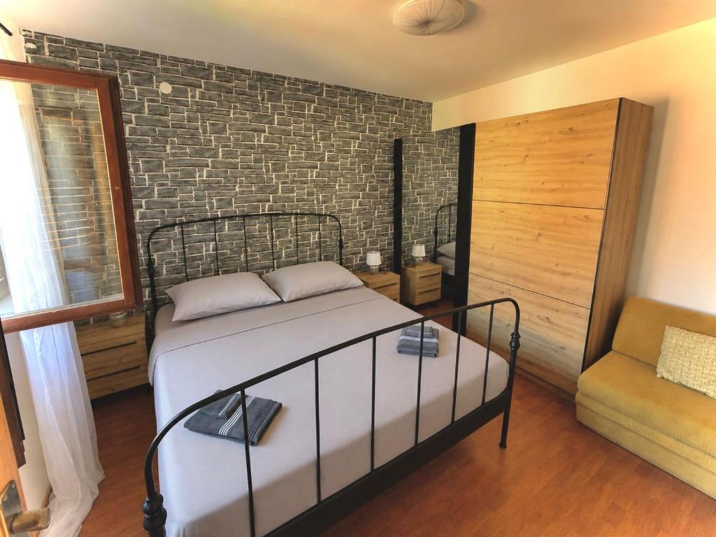 a bedroom with a bed and a brick wall at Cozy apartment Ivana in Gornji Karin