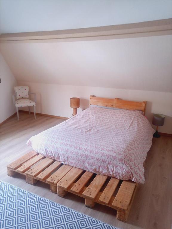 a bedroom with a wooden bed and a chair at La Détente in Rinxent