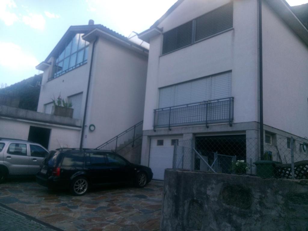 a house with two cars parked in front of it at Casa Ines in Bellinzona