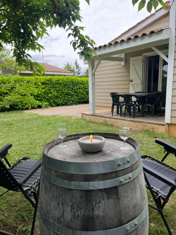a fire pit in a barrel with two wine glasses at Chalet paisible in Rivières