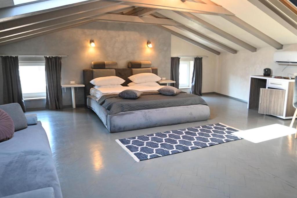 a large bedroom with a large bed and a couch at San Mauro rooms in Poreč