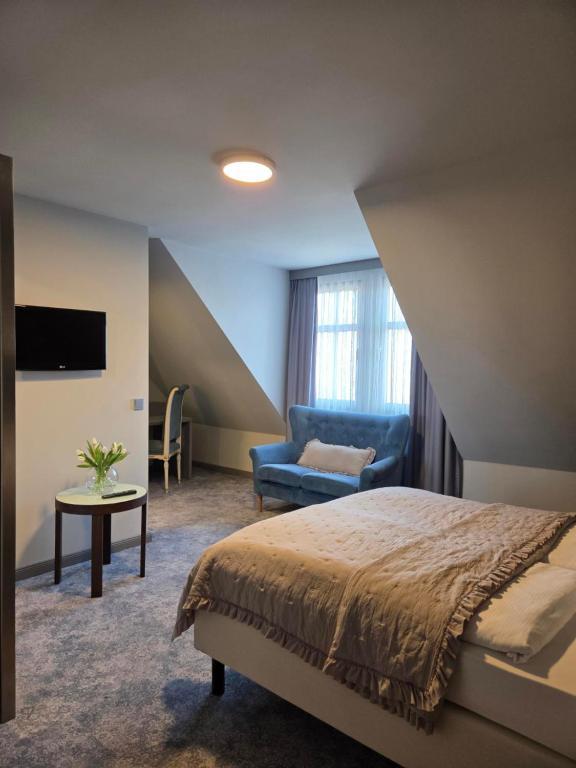 a bedroom with a bed and a couch and a chair at Hotel zur Kaiserpfalz in Kaiserpfalz