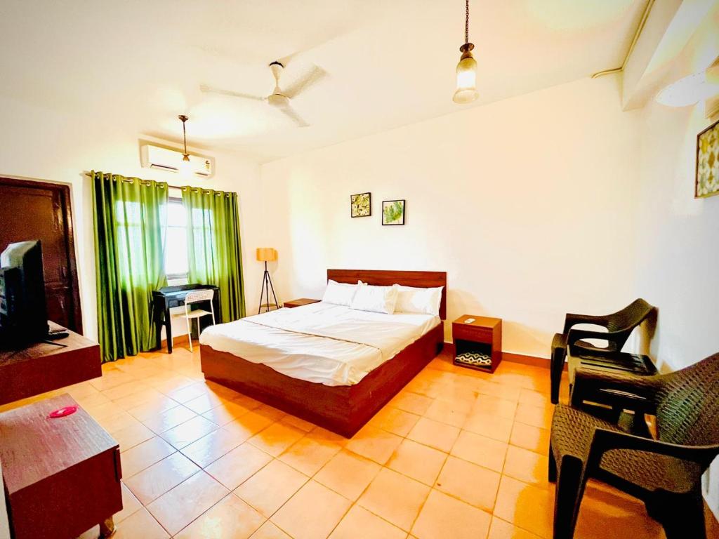 a bedroom with a bed and a tv in a room at Beachside Studio Apartment Baga in Baga