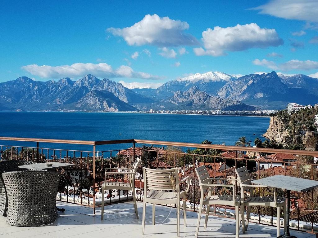 a balcony with tables and chairs and a view of the water at Patron Hotel in Antalya