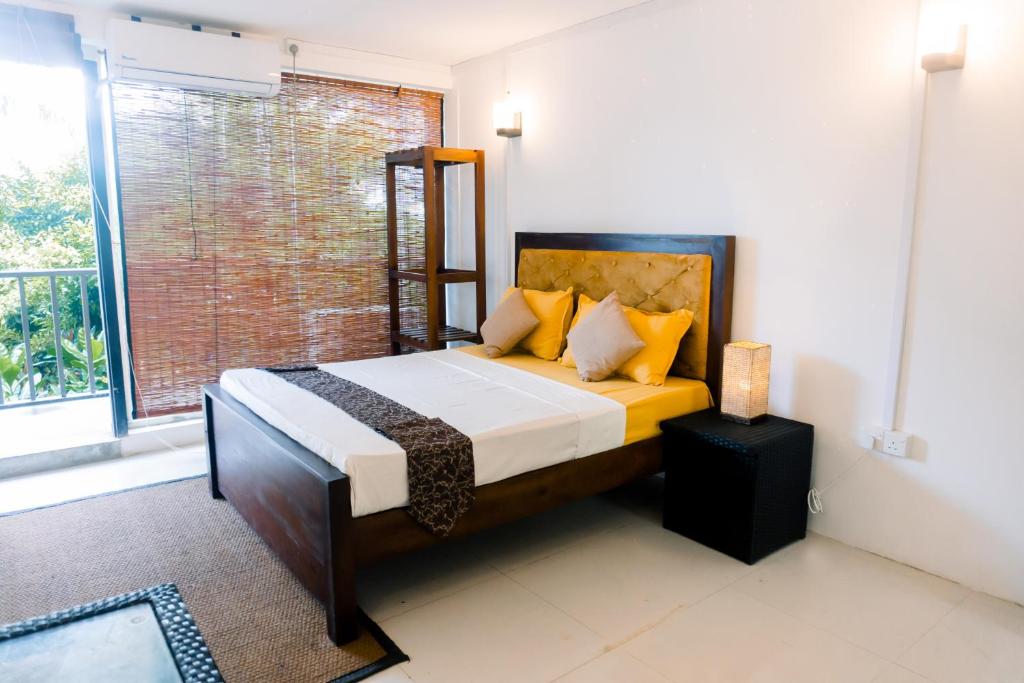 a bedroom with a bed and a window at Lavanga Express in Hikkaduwa