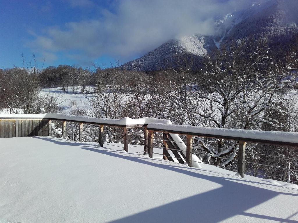 una cerca cubierta de nieve con una montaña en el fondo en Barthoux, en Seythenex