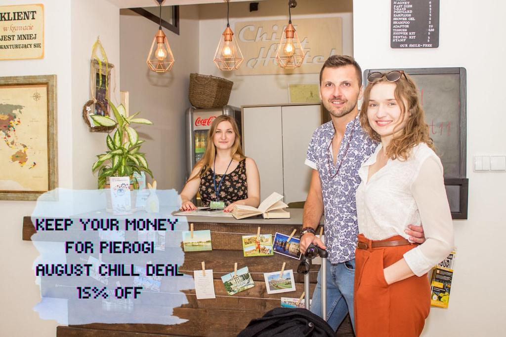 a man and a woman standing next to a counter at Chillout Hostel in Warsaw