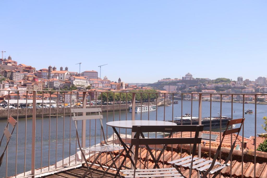 a table and chairs sitting on a balcony overlooking a marina at Gaia River View in Vila Nova de Gaia