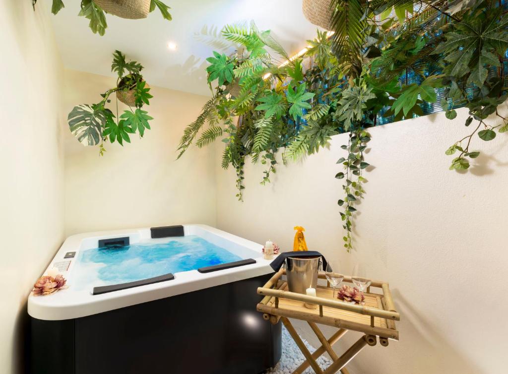 a hot tub in a room with plants at Eteria Luxury Rooms Spa & Wellness in Posada