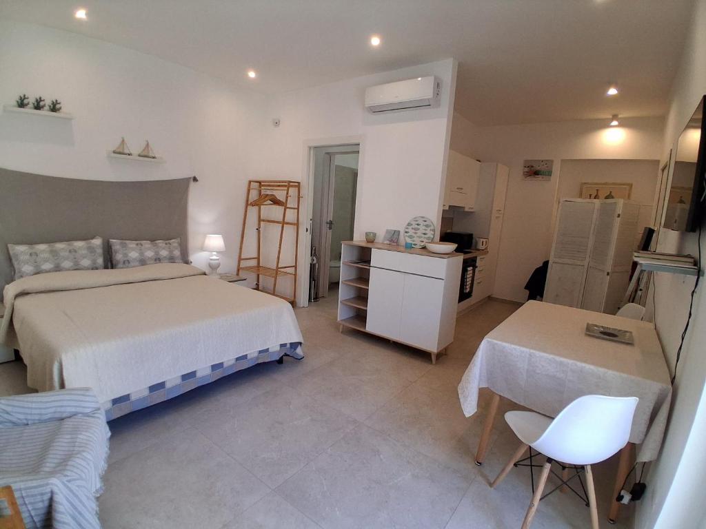 a bedroom with two beds and a table and a chair at Ca' Dora in Otranto