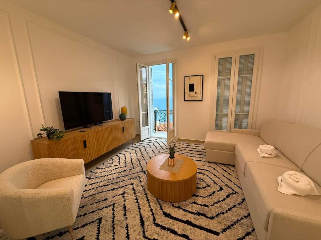 a living room with a couch and a tv at Frontière de Monaco - Spacieux et confortable - GM in Beausoleil