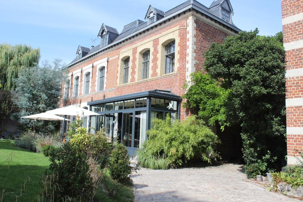 a red brick building with a garden in front of it at Maison Mathilde in Valenciennes